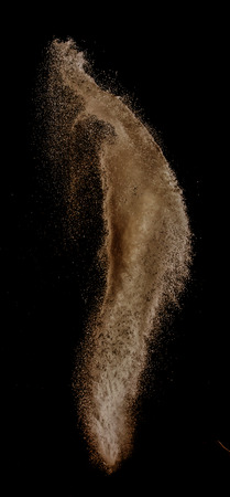 Sand explosion isolated on over dark background,Abstract sand cloud,Motion blurの写真素材