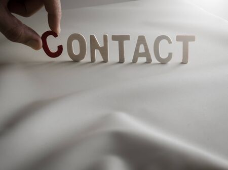 "CONTACT"word made from colored wooden letters with human's fingerの写真素材