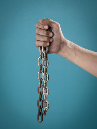 Terrorists Prisoner with chained hand against blue background,criminal conceptの写真素材