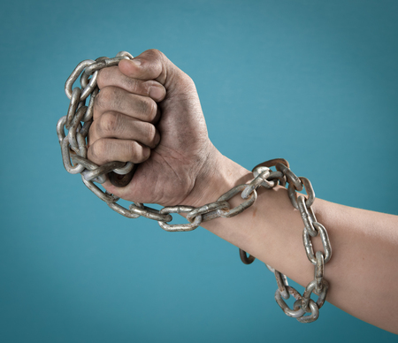 Terrorists Prisoner with chained hand against blue background,criminal conceptの写真素材