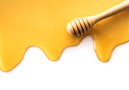 Dripping honey with wooden stick isolated on white backgroundの写真素材