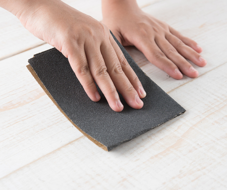 Sanding and smoothing wood with black sandpaperの写真素材