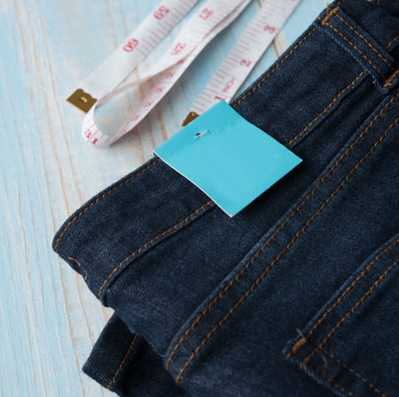 Blue jeans with blank paper price tag on wood,Logging for shop and saleの写真素材