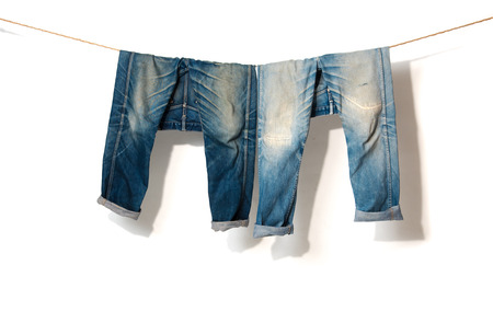 Blue Jeans hanging on a rope clothesline,white backgroundの写真素材