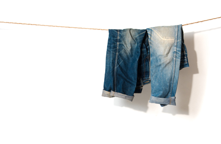 Blue Jeans hanging on a rope clothesline,white backgroundの写真素材