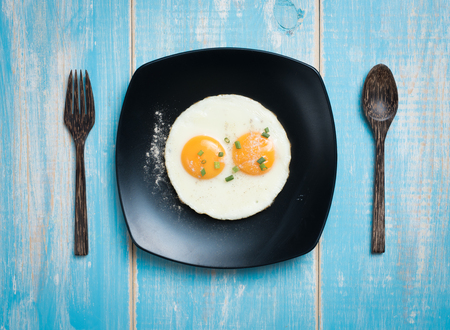 Fried eggs in a plate on a table,top viewの写真素材