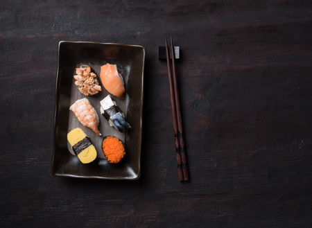 Sushi set with chopsticks on old woodenの写真素材