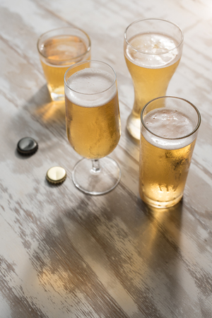 Glasses of beer with reflection on table woodenの写真素材