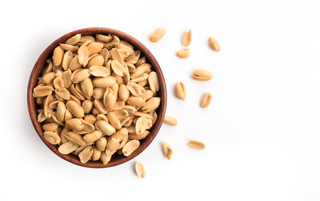 Roasted salted peanuts in wooden bowl on whiteの写真素材