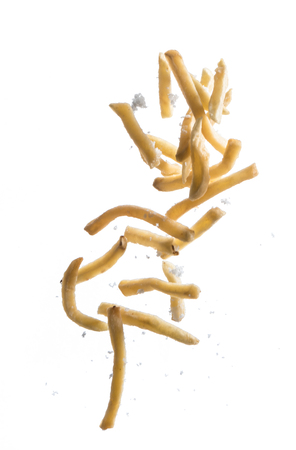 French fries with salt explode flying in the air isolated on whiteの写真素材