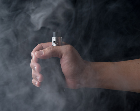 Man holding e-cigarette with smoke,vaping device