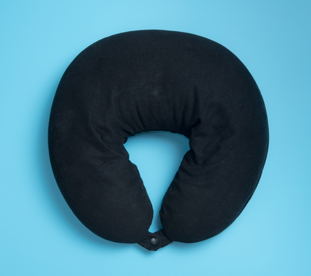 Black neck pillow on blue backgroundの写真素材