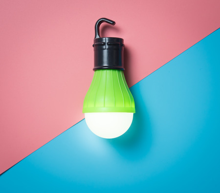 Green Light bulb on pink backgroundの写真素材