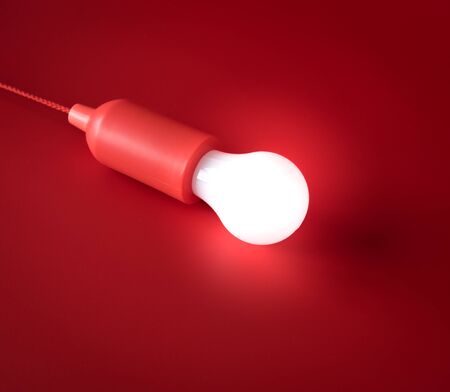 Light bulb on red background