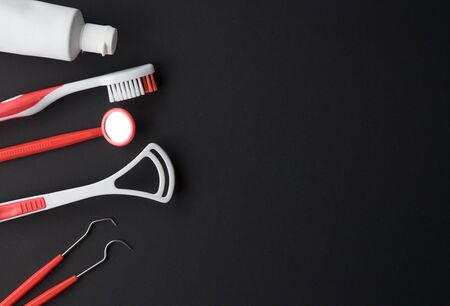 Set of different tools with toothbrushes and toothpaste tube against dark background,dental careの写真素材
