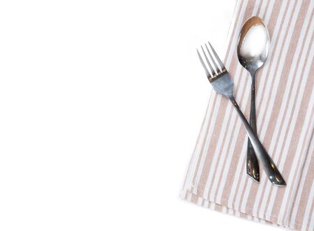 Checkered tablecloth with fork and spoon on white backgroundの写真素材