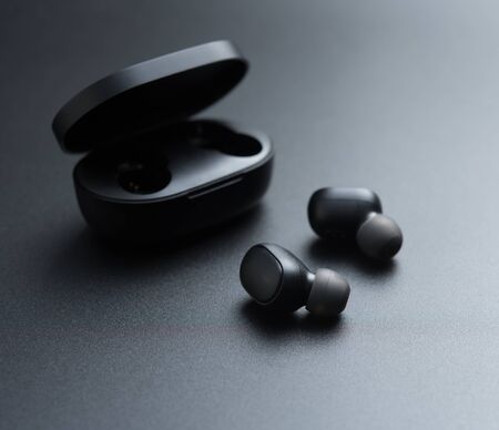 Black wireless earphones in-ear with charging caseの写真素材