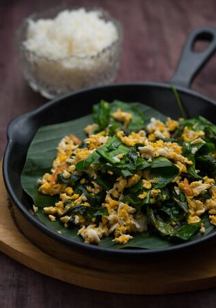 Laing leaf fried with egg on wood table,Thai foodの写真素材