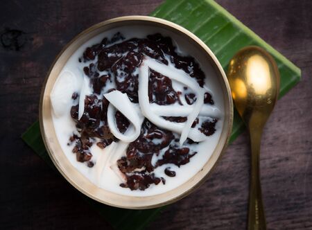 Black sticky rice with coconut milk on wood,Thai dessertの写真素材