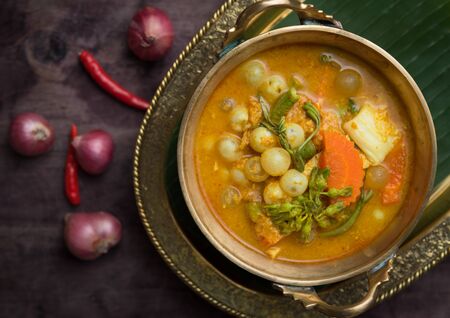 Sour curry soup with spawn and green vegetable on black wooden table,Thai foodの写真素材