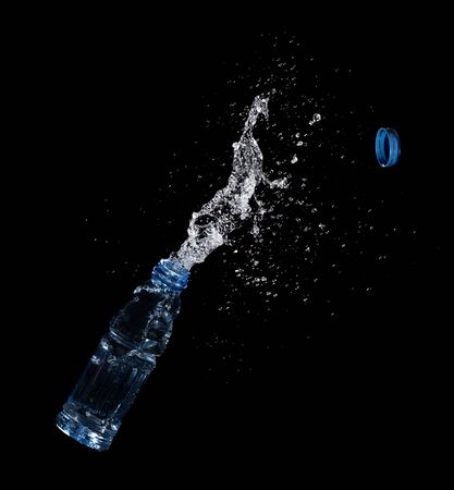 Bottle of drinking water splashing out isolated on blackの写真素材