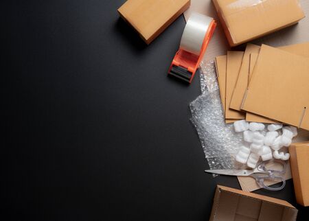 Packing accessories on dark background,Foam cushion,Shockproof plastic wrap,Cardboard boxes with...