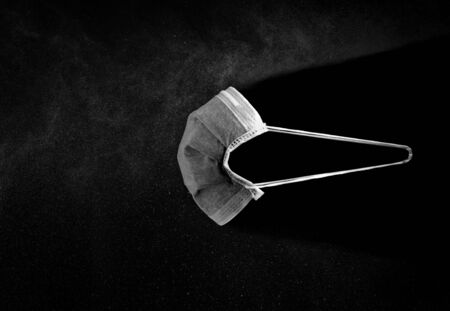 Black medical mask, Medical protection mask against viruses, bacteria, smog isolated on black backgroundの写真素材