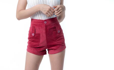 Young woman in short red pants on a white backgroundの写真素材