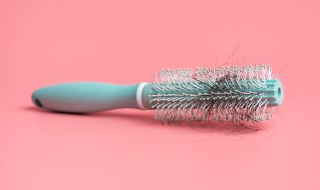 Black hair loss problem with hairbrush on pink backgroundの写真素材