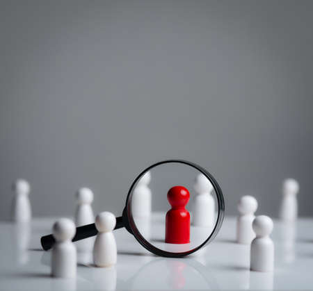 Hand putting the last piece in the puzzle on grey backgroundの写真素材