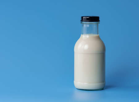 Bottle of milk on blue color background.の写真素材