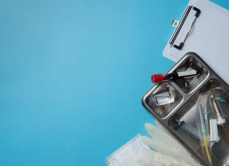 Blank medical clipboard with syringes with needles for vaccination in stainless steel surgical trayの写真素材