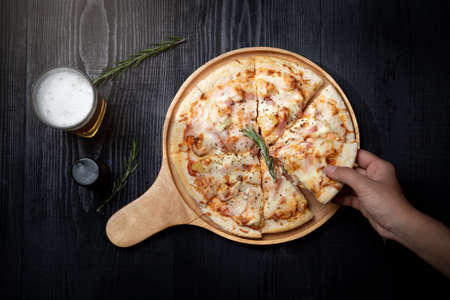 pizza Hawaiian with pineapple and ham on the tableの写真素材