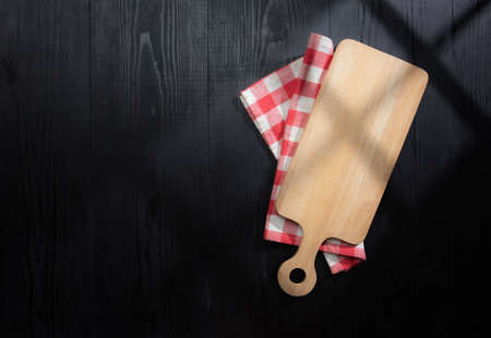 Cutting board over towel on wooden table,Top view