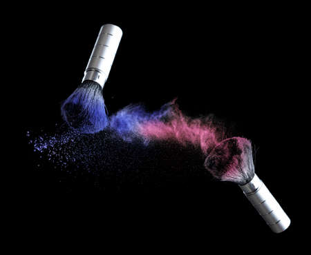 Blue and red powder splash with cosmetic brush for makeup on black backgroundの写真素材