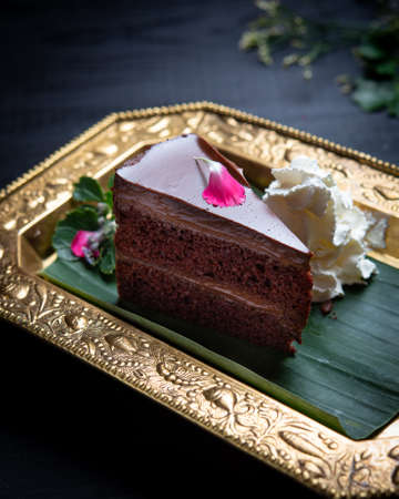 Portion of sliced delicious chocolate cake on wooden table