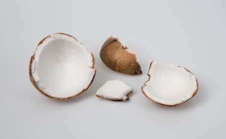 Parts of fruits coconut on a light grey background,Cracked coconutの写真素材