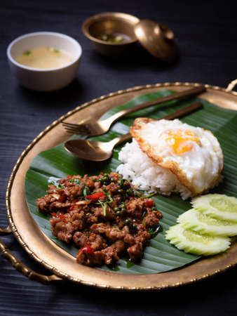 Rice topped with stir-fried pork and basil,fired egg on the tableの写真素材
