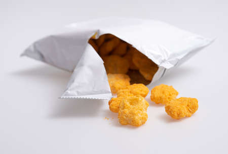 Corn puff snacks open bag packaging on blue backgroundの写真素材