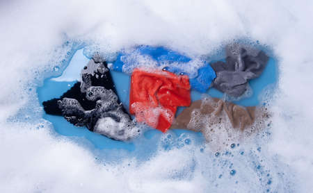 Wet color clothes with white foam Soak before washing,top view
