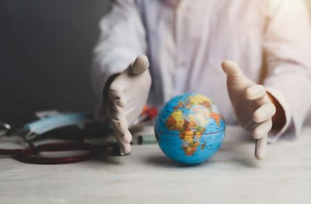 doctor's hands in medical surgical gloves with earth globe, world health day and global health care...