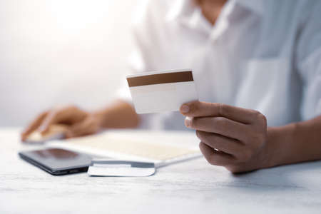 Hands holding plastic credit card and using laptop. Online shopping conceptの写真素材