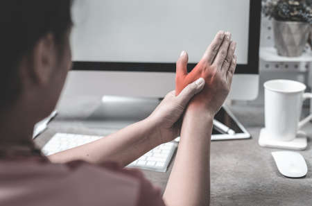 Woman holding her hand pain from using computer long time,Office syndrome conceptの写真素材