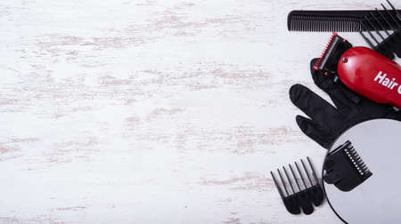 Hairdressers tool. Hair clipper on white wood with nozzles of different sizes.の写真素材