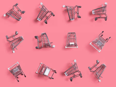 Close-up of shopping trolley on pink background,empty shopping cartの写真素材