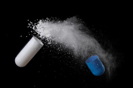 white and blue pill with exploding over a black background,Concept of medicineの写真素材