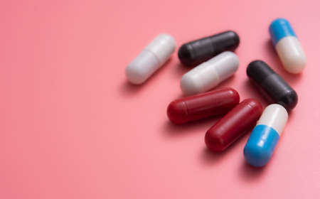 Multicolored pills,various capsule on a pink backgroundの写真素材