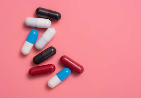 Multicolored pills,various capsule on a pink backgroundの写真素材