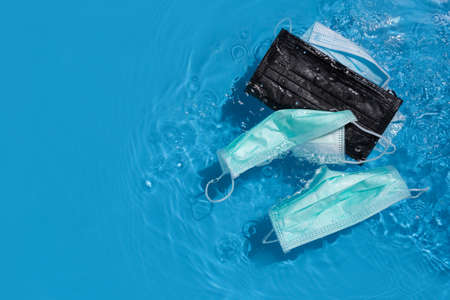 Used face mask floating in the Dirty river, Freshwater pollution concept,top view
