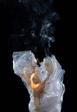 The fire is burning plastic bag on a dark background.の写真素材